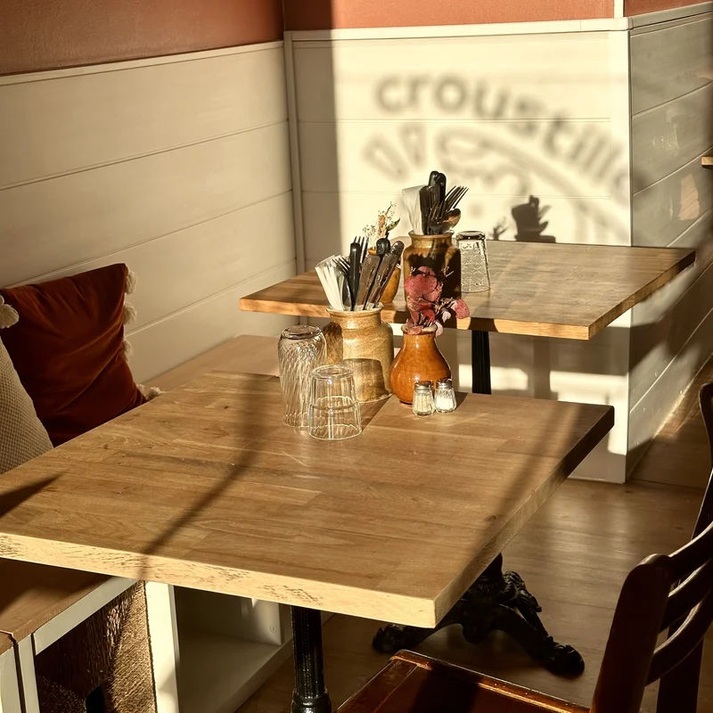 tables bistrot et l'ombre du logo croustille sur le mur